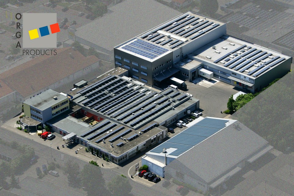 Luftaufnahme des Industrieareals der Greim Gruppe in Wörrstadt mit mehreren Gebäuden, deren Dächer mit Solaranlagen ausgestattet sind. Die Aufnahme unterstreicht den Fokus des Unternehmens auf nachhaltige Logistik- und Fulfillment-Dienstleistungen.